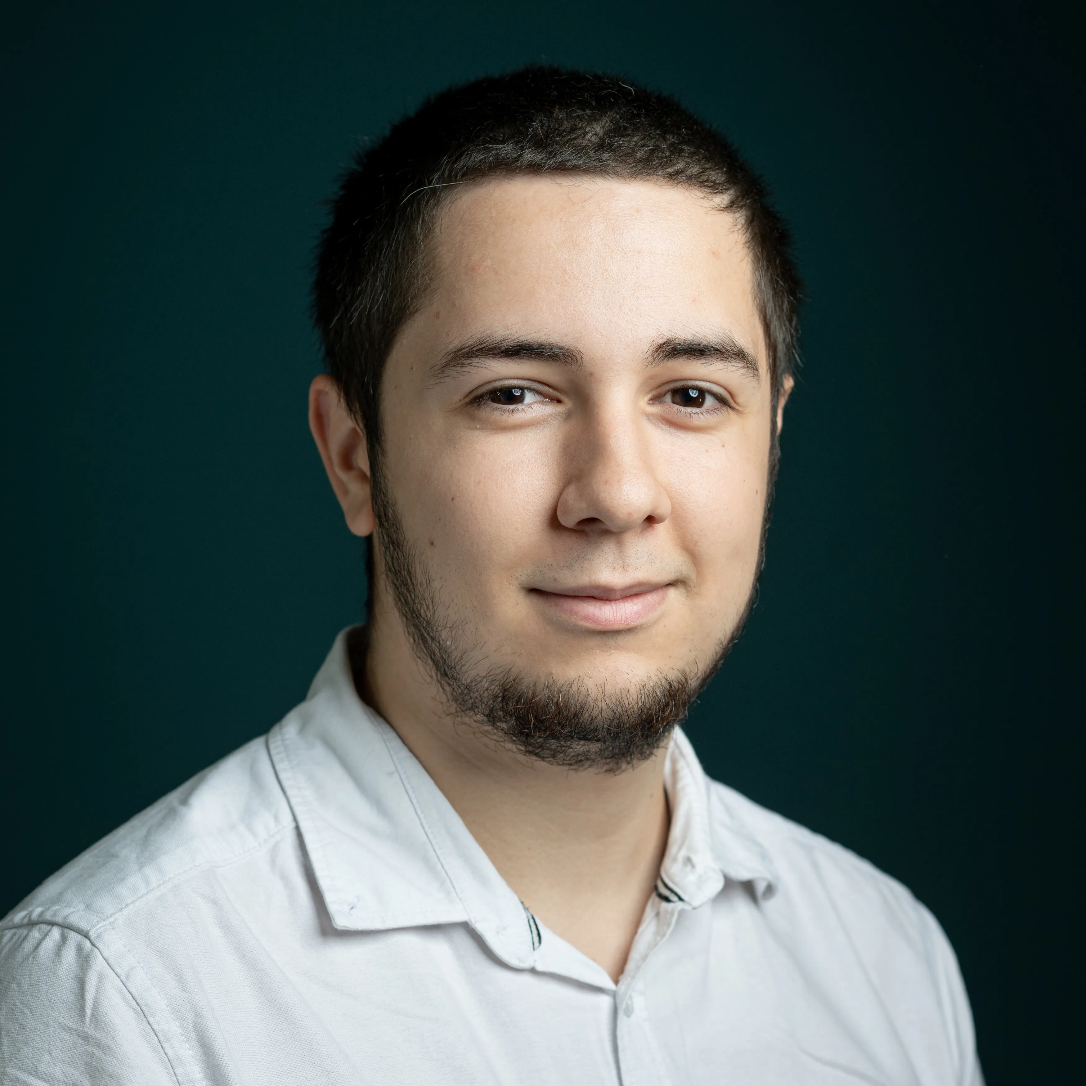 Portrait of Yann Grallan, white shirt, studio lighting.